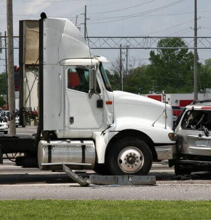 Image of an automobile accident between semi truck and car.