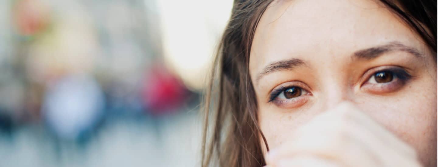 A close up of woman with her hands covering her face